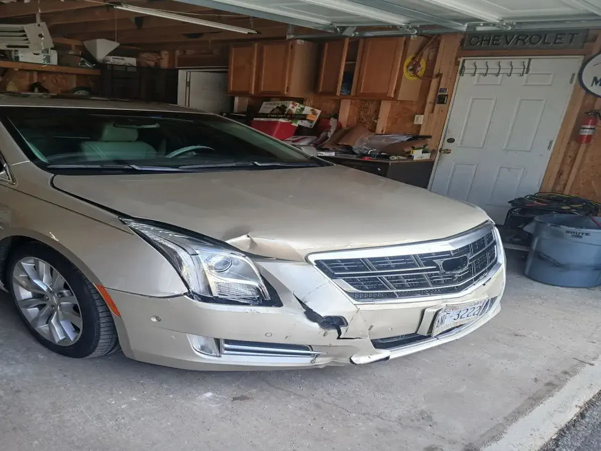 Brown Cadillac with front end crash damage before repair