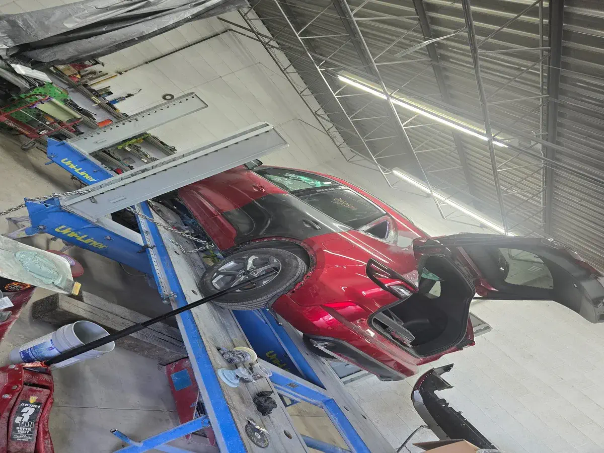 Red SUV with a damaged passenger door before repair